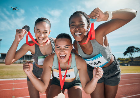 Happy women, medal and celebration in olympic winning, running or competition together on stadium track. Group portrait of athletic people in happiness, award or victory in sports marathon or successの写真素材