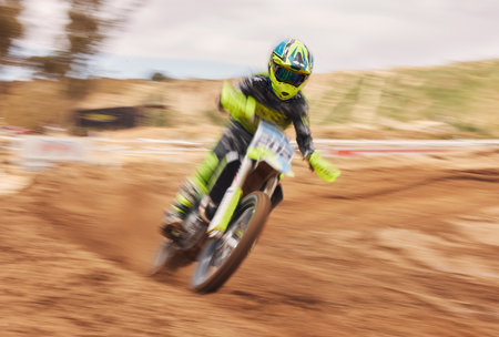 Dirt, motion blur and motorbike cycling for sports, agile driving and off road adventure for speed, power or performance. Motorcycle, rally and driver in fast race, challenge or action on sand courseの写真素材