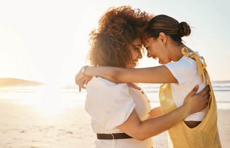 Love, mockup and an lgbt couple on the beach together for romance or relationship bonding on a date. Sunset, nature and a gay woman with her lesbian girlfriend by the sea or ocean for their honeymoonの写真素材