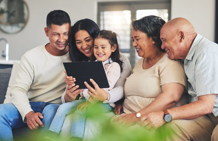 Tablet, family and children on a sofa in the living room together during a visit with grandparents...