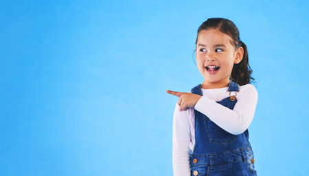 Pointing, blue background and child with mockup space for banner, advertising and promotion....