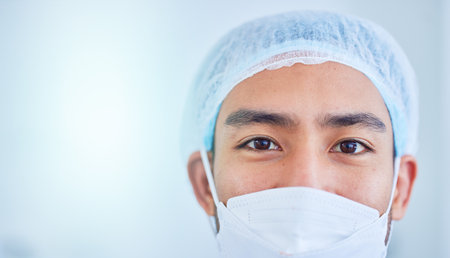 Face mask, surgeon and man in hospital in studio isolated on a white background mockup space. Portrait, doctor and medical professional nurse, healthcare worker and confident surgery employee in ppe.の写真素材