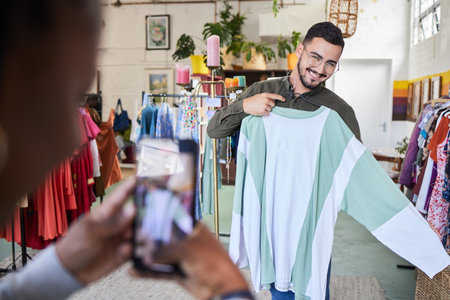 Man, shopping and clothes with photography, phone and happy for check, quality assurance or discount in mall. Designer, smartphone and fashion in boutique with promotion, deal or post on social mediaの写真素材