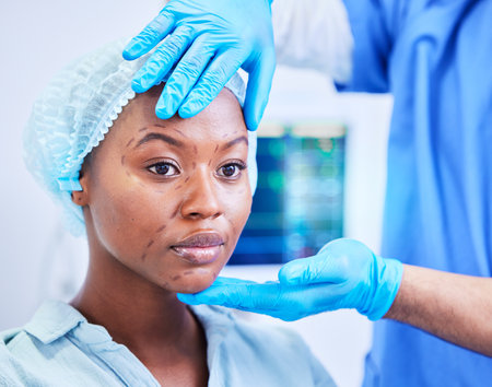 Black woman, patient and hands, plastic surgery and face with doctor, health and medical consultation with beauty. Help, medicine and cosmetic procedure, exam and healthcare with people at hospitalの写真素材