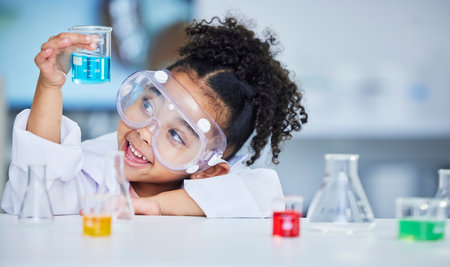 Science, eduction and smile with child in laboratory for experiment, learning and research. Future, study and knowledge with face of young girl and chemicals for results, medicine and analysisの写真素材