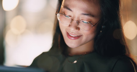 Business woman, face or tablet in night office on digital marketing ideas, advertising strategy planning or branding growth innovation. Smile, happy or creative Japanese designer working late on techの写真素材