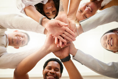 Office, team building and hands together from below in huddle for teamwork, collaboration and motivation at startup. Work, goals and diversity, group of people with business growth and staff support.の写真素材