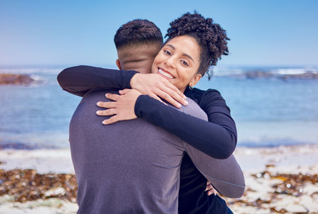 Fitness, portrait and couple hug at a beach for sports, training and morning cardio in nature. Face, smile and happy woman embrace man at the ocean for running, workout or wellness exercise with loveの写真素材