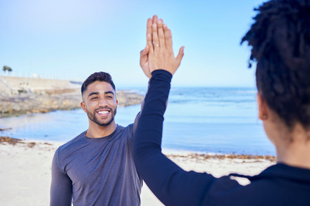 Fitness, couple and high five on the beach for exercise, outdoor workout or training for water...