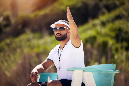Summer, sports and a volleyball referee on the beach in a chair for authority, rules or regulations during a game. Health, professional or competition with a man refereeing a match outdoor in the dayの写真素材