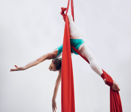 Aerial, woman gymnast and training performance with stretching, flexibility split and athlete with white background. Workout, exercise and gymnastics with balance art and dance acrobat competitionの写真素材