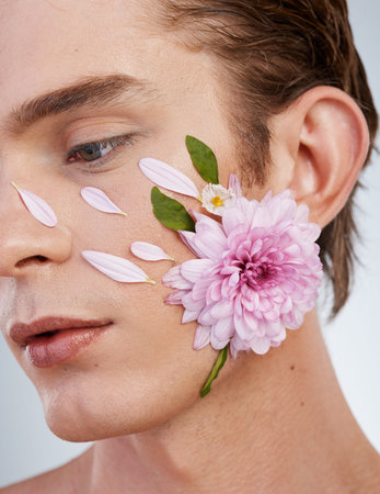 Natural, skincare and flowers on face of man in studio for spring, beauty cosmetics and creative....