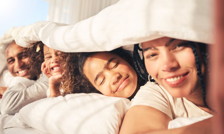Happy family, bed and selfie in home bedroom while together in morning for portrait. African woman, man and kids lying under blanket for social media, profile picture or relax on influencer holidayの写真素材