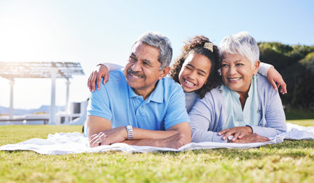 Grandparents, girl and blanket on grass, relax and smile with hug, love and picnic on family...