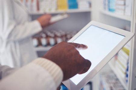 Typing, pharmacy and hands with a tablet for a search, check of stock or medicine update online. Closeup, connection and medical employee on technology for healthcare inventory or website at a clinicの写真素材