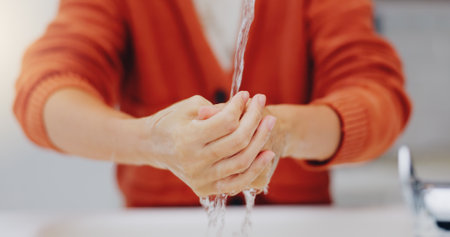 Washing hands, water and cleaning at sink in bathroom for hygiene, wellness or health. Skincare, liquid and woman clean hand to remove bacteria, germs and dirt, sanitary and disinfection in home.の写真素材