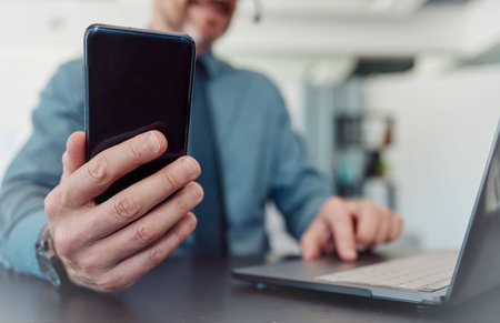 Businessman, hands and phone with laptop in communication, social media or networking at the office....