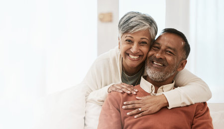Portrait, smile and senior couple in home living room, bonding together and hug on mockup space. Happy face, man and Indian woman in lounge for care, love or support in healthy relationship at houseの写真素材