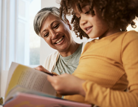 Home, happy family grandmother and child reading book, study kindergarten storybook and old woman babysitting grandchild. Love, happiness and grandma support, care and helping kid with home educationの写真素材