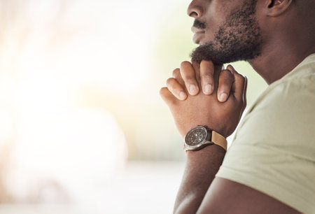 Prayer, religion and hands of man for worship, faith and belief for support, help and hope. Mockup space, praying and closeup of person in home for meditation, spiritual healing and trust for praiseの写真素材