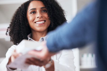 Pharmacist, woman and smile with customer pills in store with healthcare and medical help. Pharmacy, happy and supplements information with a professional with client package in pharmaceutical shopの写真素材