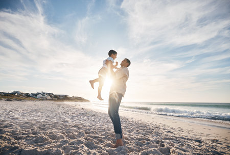 Blue sky, father and child on beach, playing and bonding together on summer vacation in Hawaii. Sand, sun and ocean, dad and son with playful games on tropical island holiday with love, trust and funの写真素材