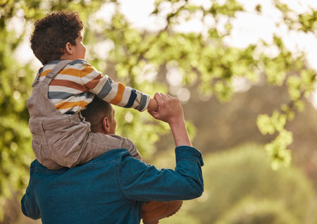 Piggyback, love and father with child in park for support, playful and games. Relax, freedom and adventure with man carrying baby in nature for family, summer and vacation together with mockup spaceの写真素材