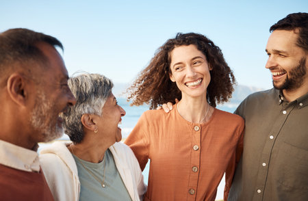Family, parents and couple laughing at the beach for holiday or vacation together and bonding for happiness. Travel, man and woman with elderly people for happy at the sea or ocean with freedomの写真素材