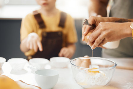 Hands, crack egg and cooking in kitchen on bowl on table with family in home. Food, bakery and break...