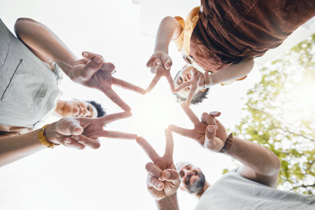 Family, hands together and star fingers outdoor in low angle, happy and bonding. Father, mother and child huddle in love, solidarity and interracial support in cooperation, connection and successの写真素材