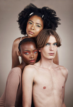 Makeup, beauty and portrait of people in studio with creative, cosmetic and facial art. Lgbtq, diversity and young man and women models with face cosmetology or skincare isolated by brown background.の写真素材
