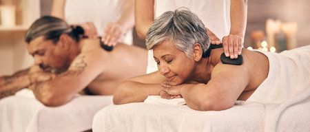 Relax, hot stone and zen with old couple in spa for vacation, luxury and beauty salon. Peace, wellness and holiday with senior woman and man in hotel villa for retirement, massage and body careの写真素材