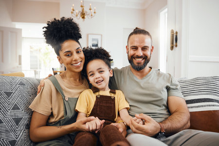 Interracial family, portrait and parents with child relax on couch, bonding and happy together at home. Smile, love and care with trust and support, people in living room, man and woman with kidの写真素材