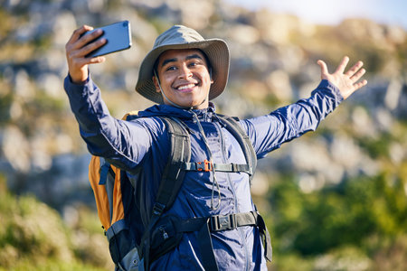 Selfie, smile and a man hiking in the mountains for travel, adventure or exploration in summer....