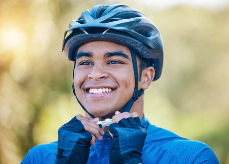 Exercise, cycling helmet and man outdoor for sports, workout or training with happy smile. Face of young athlete or cyclist with safety, wellness and fitness at park or thinking to start performanceの写真素材