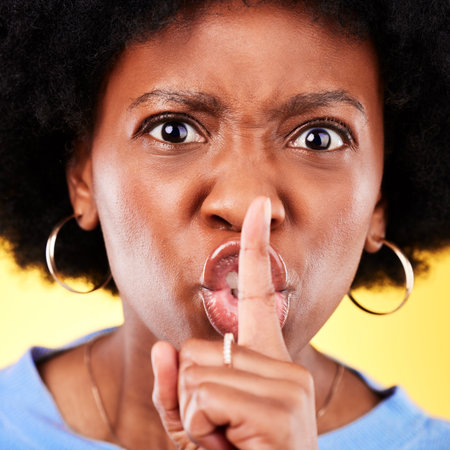 Angry portrait, woman and secret on lips in studio for privacy, drama and noise on yellow...
