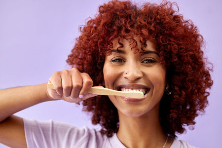 Face, smile and woman brushing teeth with wood in studio isolated on purple background. Portrait,...