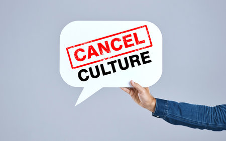 Hands of person, cancel culture and speech bubble for voice, support and opinion on grey background in studio. Poster, ban and social media influencer for freedom of vote, politics and propagandaの写真素材