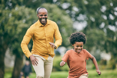African father, son and running in park, funny game and speed with freedom, care and love on holiday. Black man, young boy and comic playing with smile, outdoor and happy in summer sunshine on lawnの写真素材