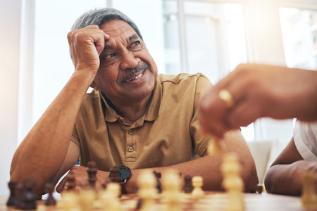 Senior man, home and chess for competition, game and strategy with friend for focus and relax in living room. Thinking, elderly and person with board for challenge, planning and mindset in houseの写真素材