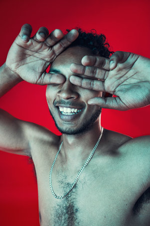 Man, hands and cover eyes in studio, smile and topless for body health and wellness on red background. Skin, person and aesthetic for cosmetics, skincare and healthcare with muscles and happyの写真素材