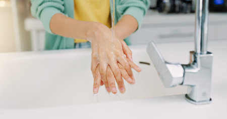 Washing hands, woman cleanse and kitchen sink of a female with soap for cleaning and wellness. Home,...