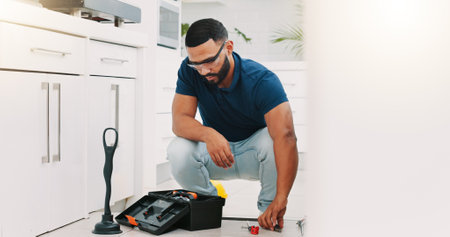 Plumber man, tools and box on floor maintenance with packing, focus and pipe repair service in house. Entrepreneur handyman, plumbing expert and small business owner with toolbox in home kitchenの写真素材