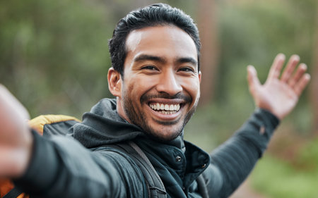 Hiking man, selfie and smile outdoor with pride, show environment and adventure in forest for wellness. Guy, photography and memory with profile picture, live streaming or post on social networkの写真素材