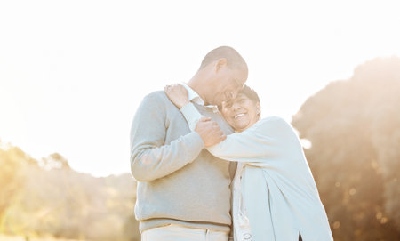 Nature, sunset and senior couple hugging, laughing and bonding on a romantic date in a park. Happy,...