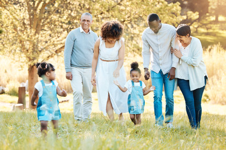 Nature, happy and family generations in a park for bonding, having fun and talking together. Love, smile and children walking with parents and grandparents in an outdoor green garden on weekend trip.の写真素材