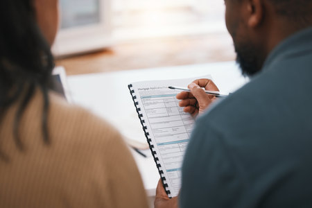 Couple, mortgage paperwork and loan application with finance, investment and property opportunity. People apply for new home together, writing on documents and information, back view with real estateの写真素材