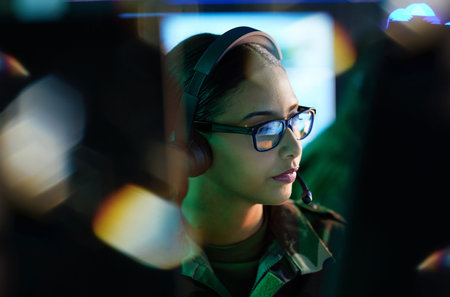 Military control room, security and woman monitor CCTV, global army network or online surveillance system. Data center, cyber support soldier and face of person helping with crime safety serviceの写真素材