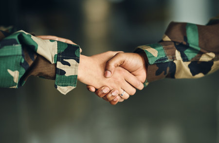 Meeting, army or shaking hands for partnership, teamwork or deal in war, agreement or unity together. Closeup, soldiers or handshake for team fight, thank you or gratitude in solidarity or militaryの写真素材