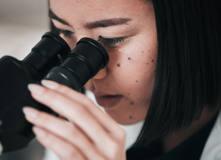 Science, microscope and closeup of Asian woman in laboratory for research, analysis and study. Biotechnology, healthcare and scientist with equipment for medical innovation, sample and DNA testの写真素材
